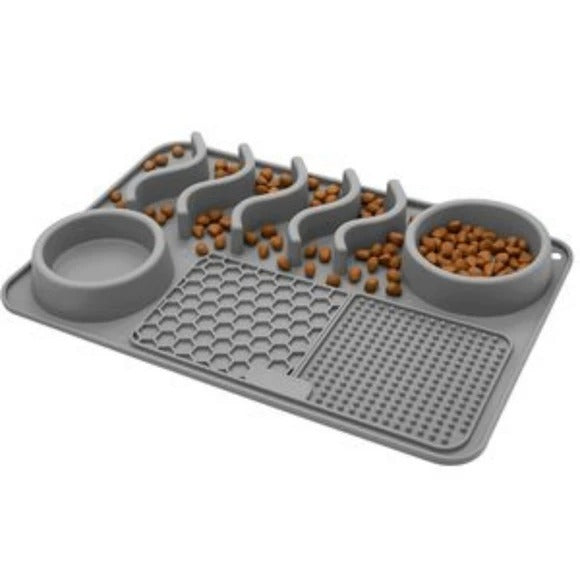 Grey silicone slow feeder pet mat with two bowls, wavy channels and textured lick pads, filled with kibble